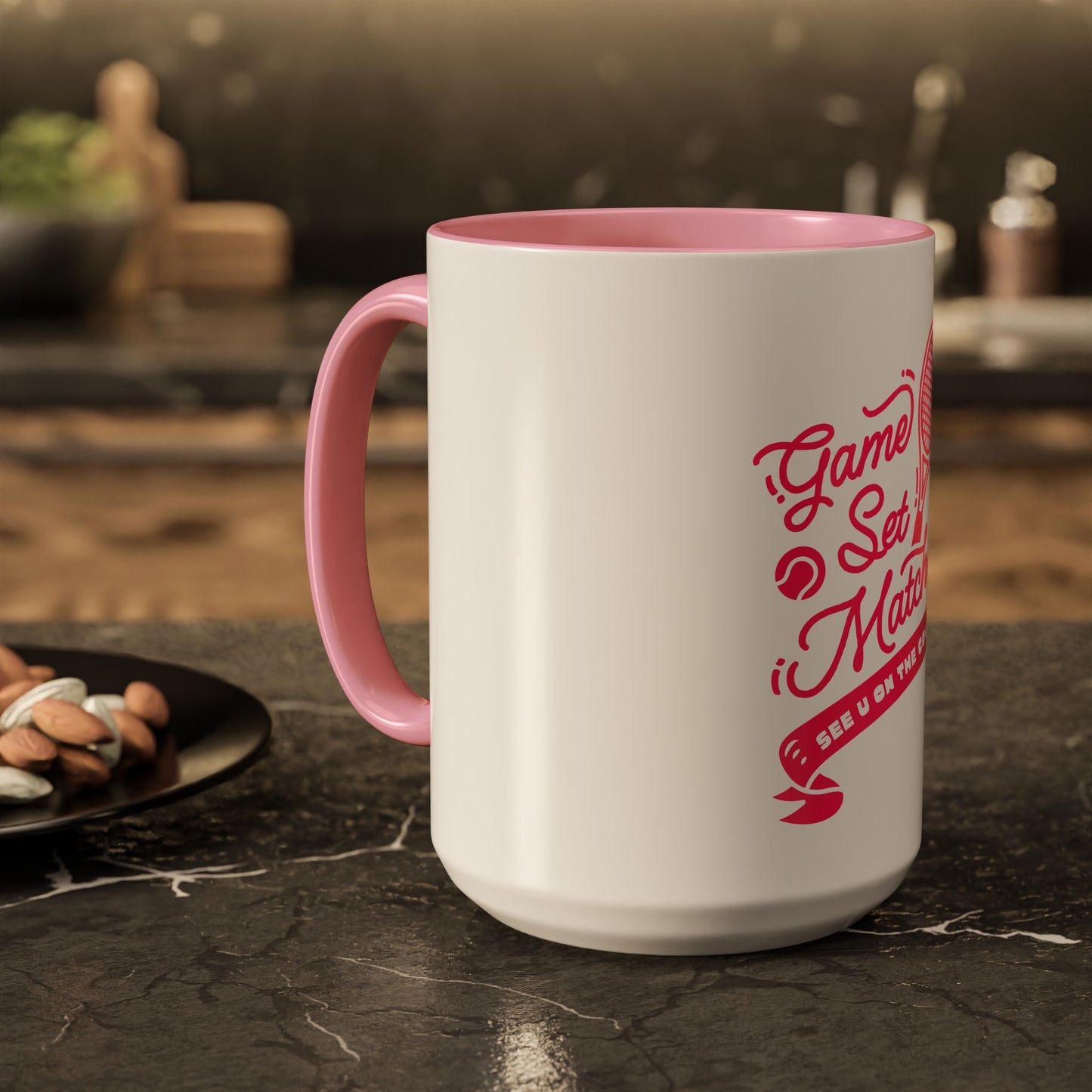 White mug with pink handle and red text on a kitchen counter