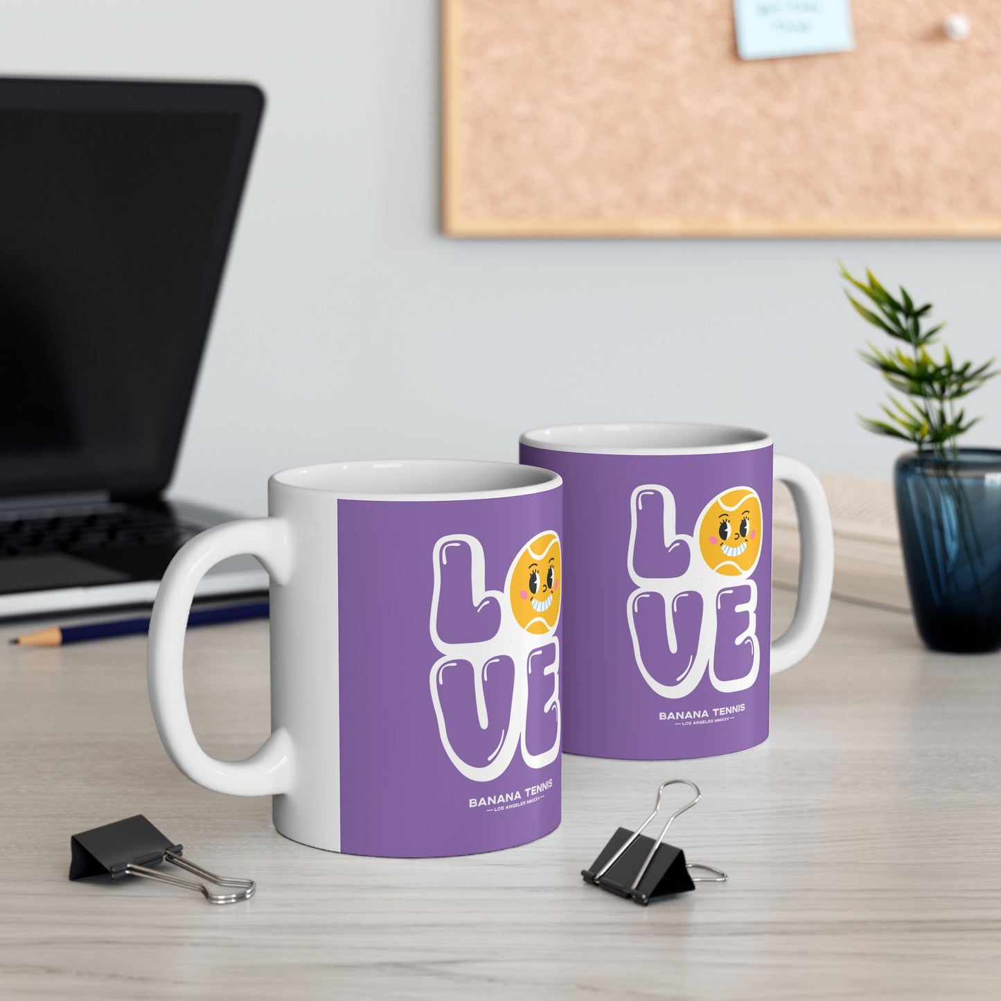 Two mugs with 'LOVE' design on a desk with office items.