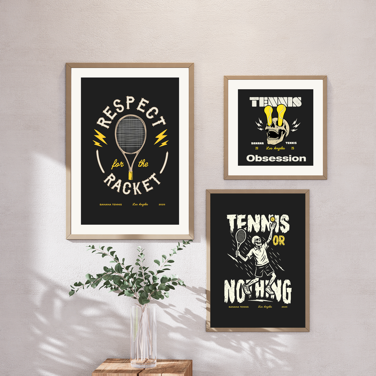 Three framed tennis-themed prints on a wall with a vase of greenery below.