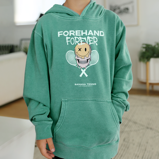 Green hoodie with 'FOREHAND FOREVER' graphic worn by a person indoors.