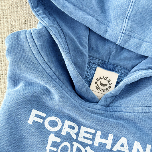 Blue hoodie with 'Forehand' text and a visible brand label on a textured surface