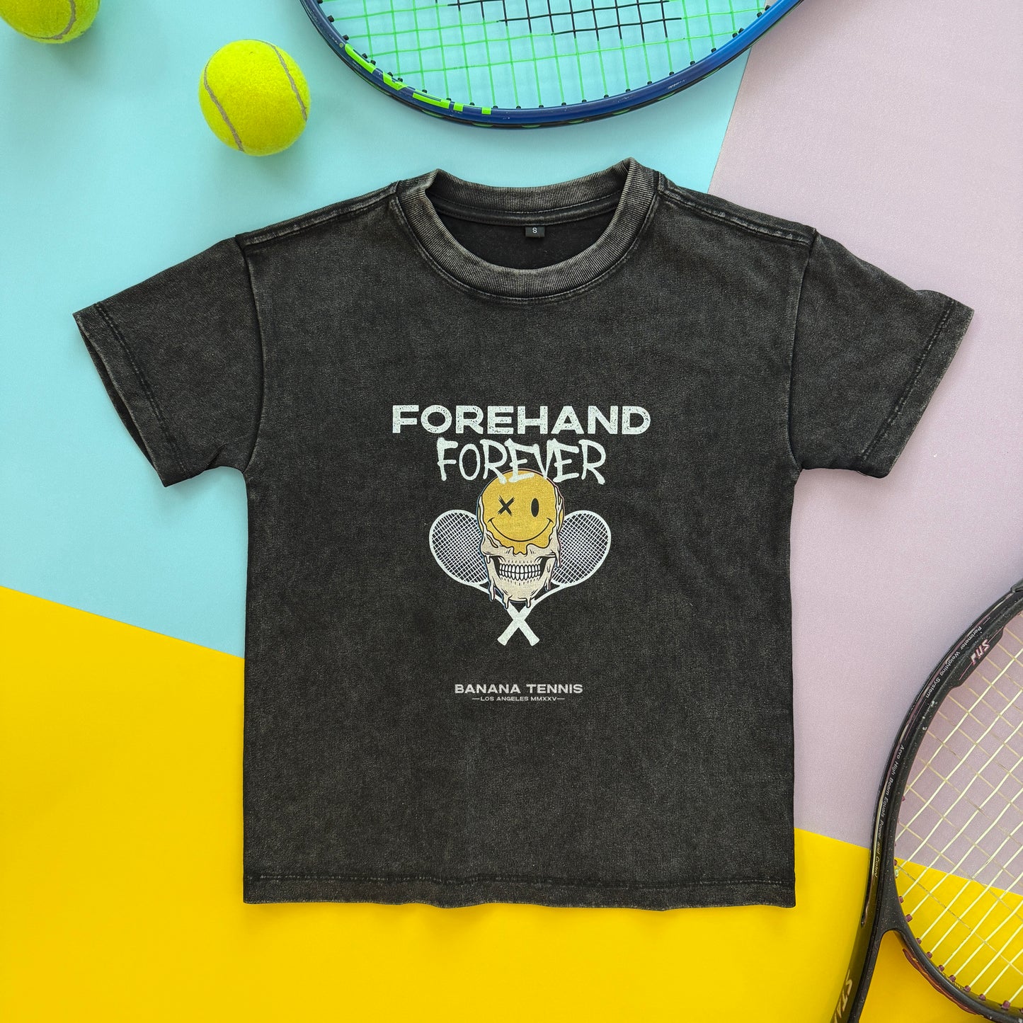 Black t-shirt with 'Forehand Forever' graphic on a colorful background with tennis balls and rackets.
