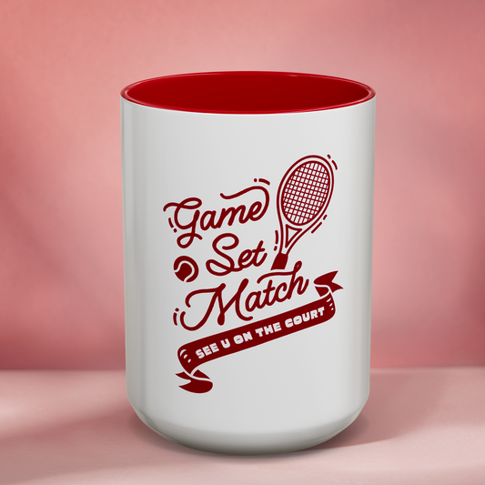 White mug with red interior and tennis-themed design on a pink background
