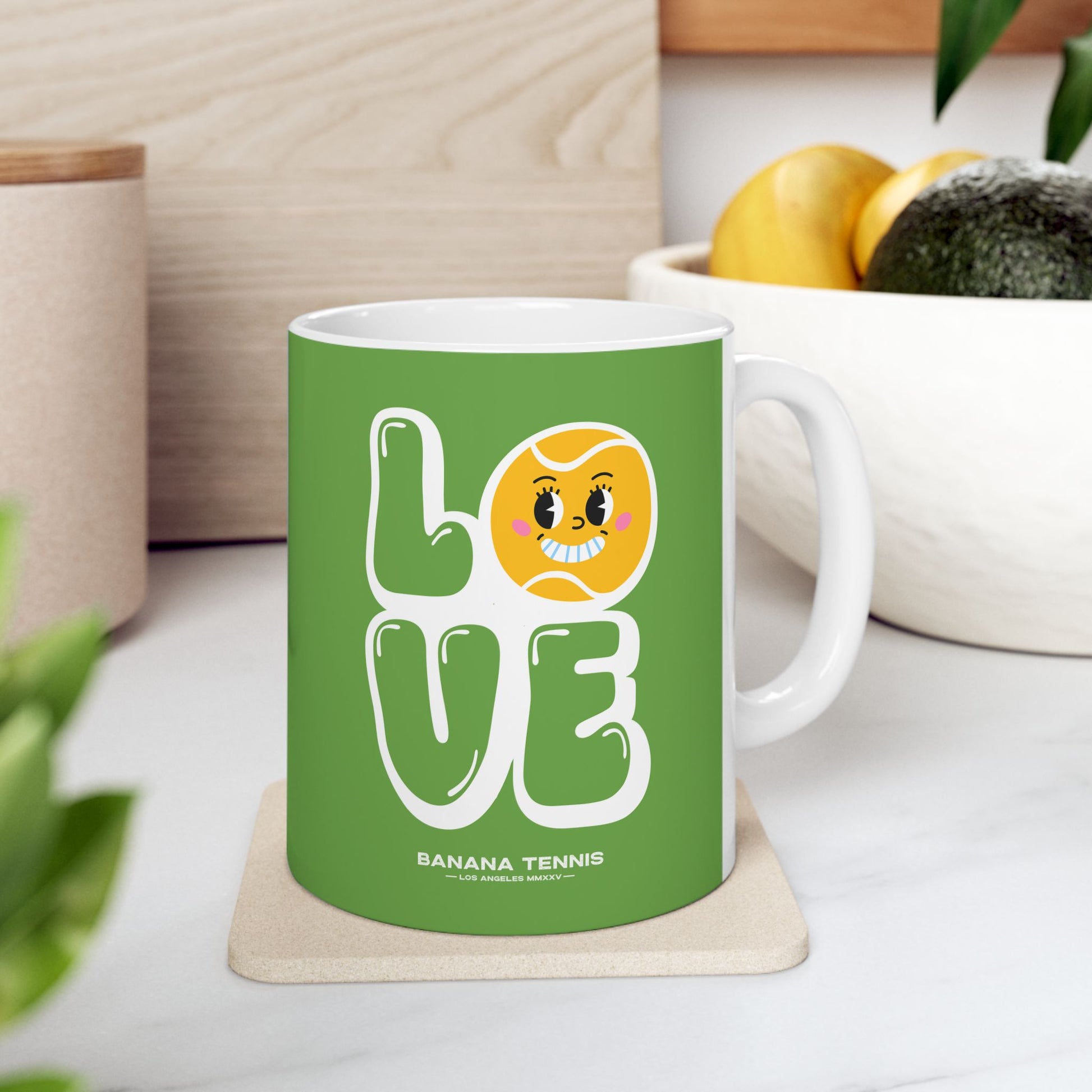 Green mug with a banana-themed design on a white surface