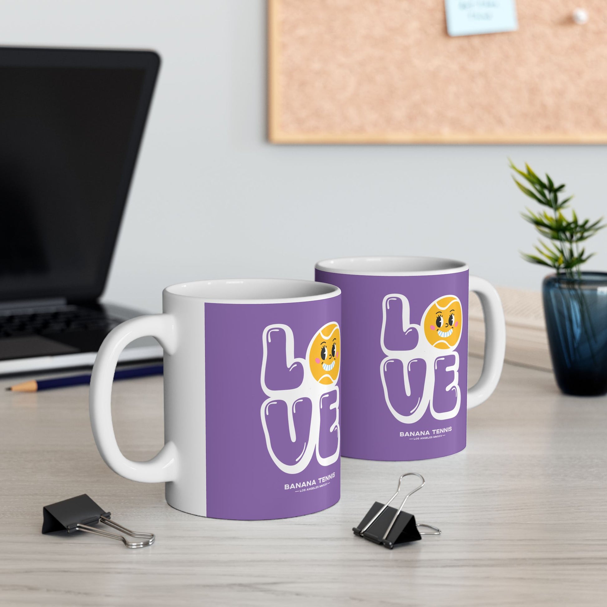 Two mugs with 'LOVE' design on a desk with office items.
