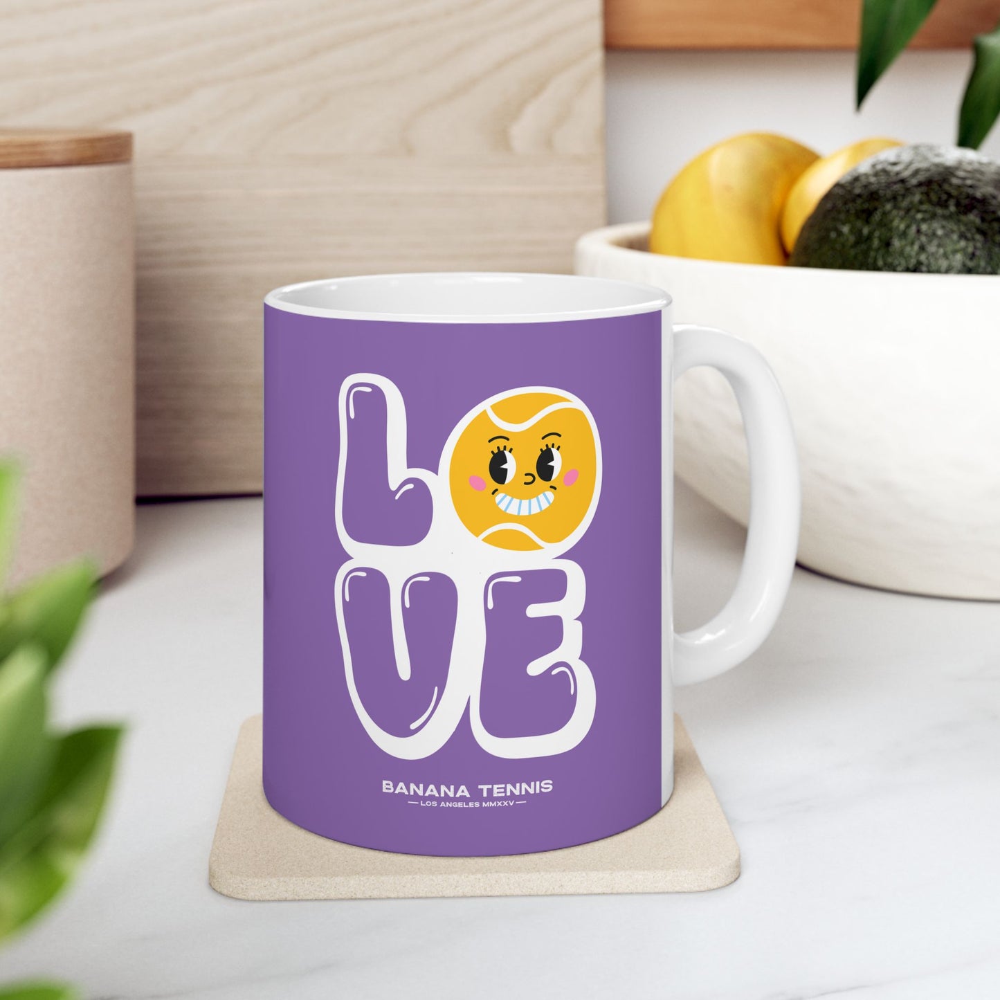 Purple mug with a banana-themed design on a white surface