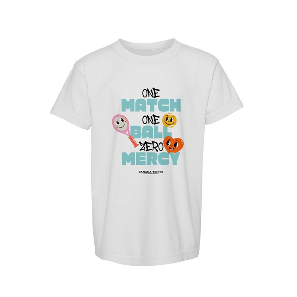 Flat-lay of white t-shirt with playful 'ONE MATCH ONE BALL ZERO MERCY' text and smiling tennis ball characters in orange, yellow, and pink