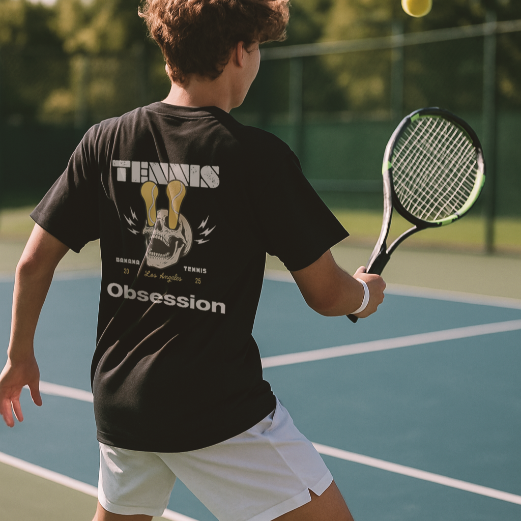 Person playing tennis on a court wearing a black 'Tennis Obsession' t-shirt.