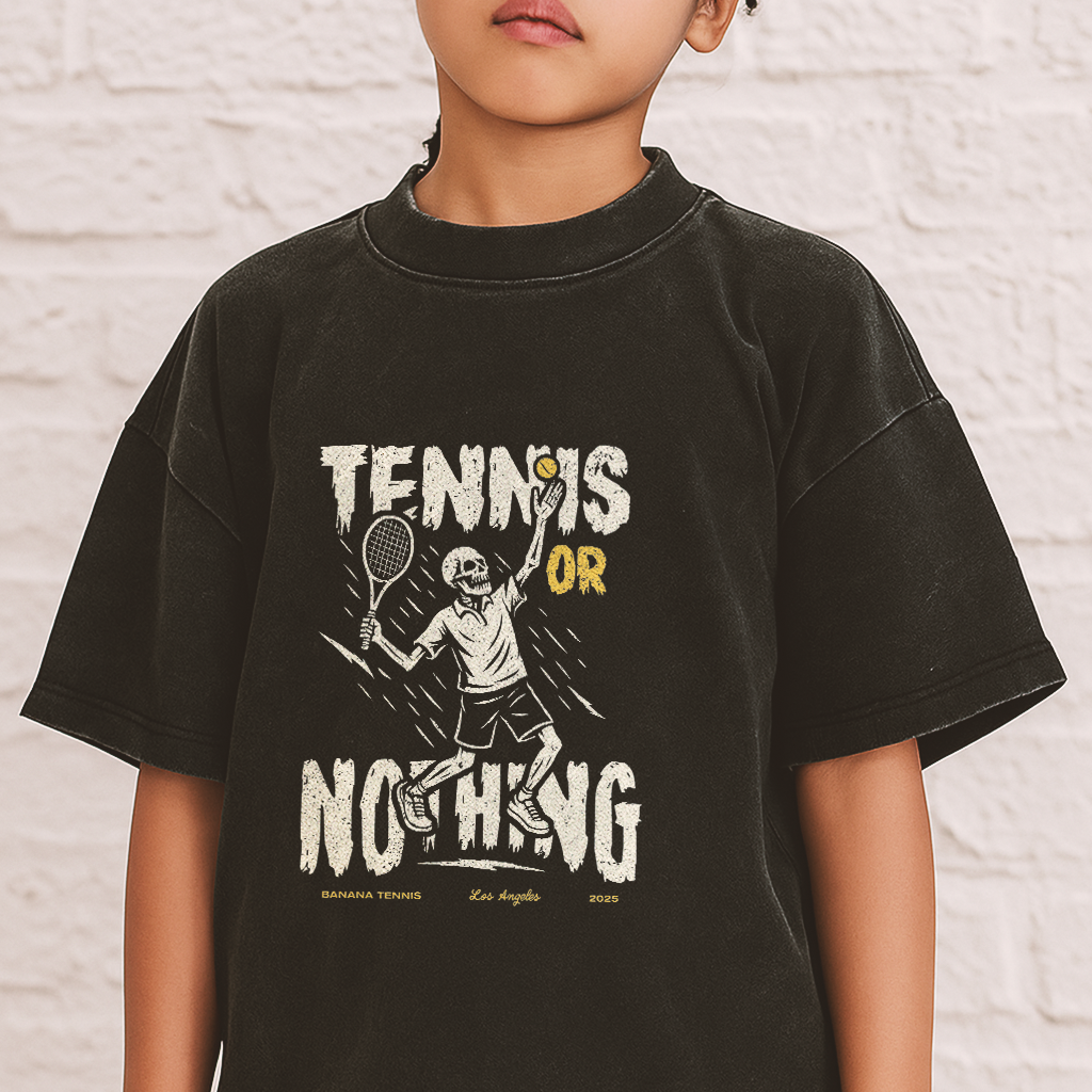 Child wearing a black t-shirt with 'Tennis or Nothing' graphic design.