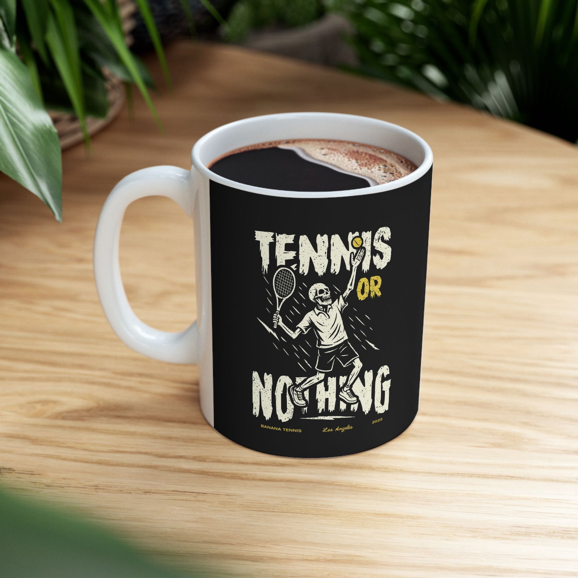 Black mug with 'Tennis or Nothing' design on a wooden table